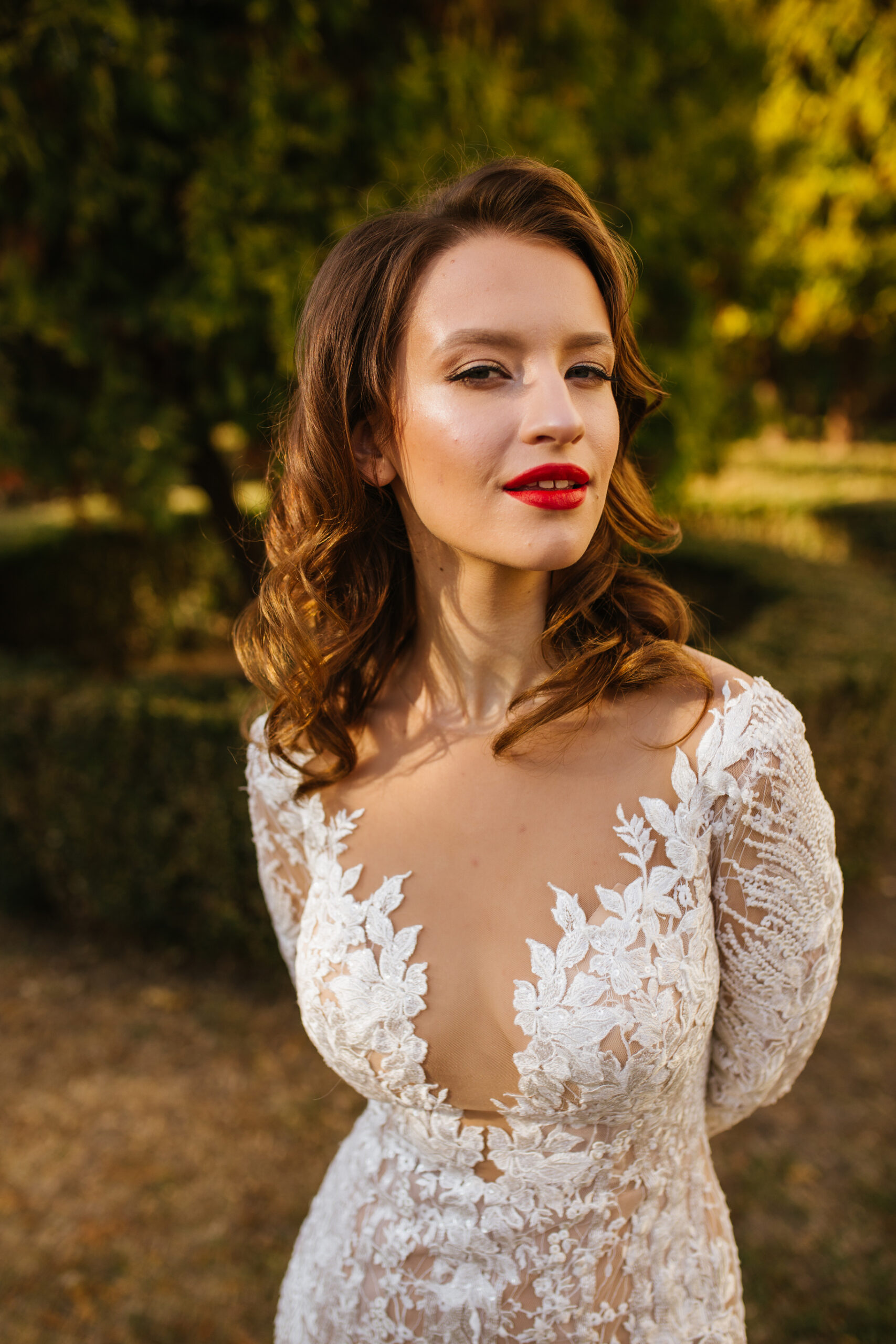 A portrait of a dreamy lady in a wedding dress posing indoor with flowers. Wedding, beauty, fashion.