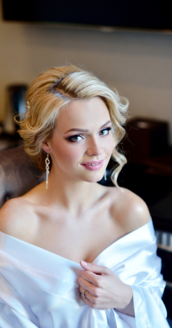 Beauty bride in dressing gown with bridal makeup indoors. Beautiful model girl in colorful wedding robe. Female portrait of cute lady. Woman with hairstyle