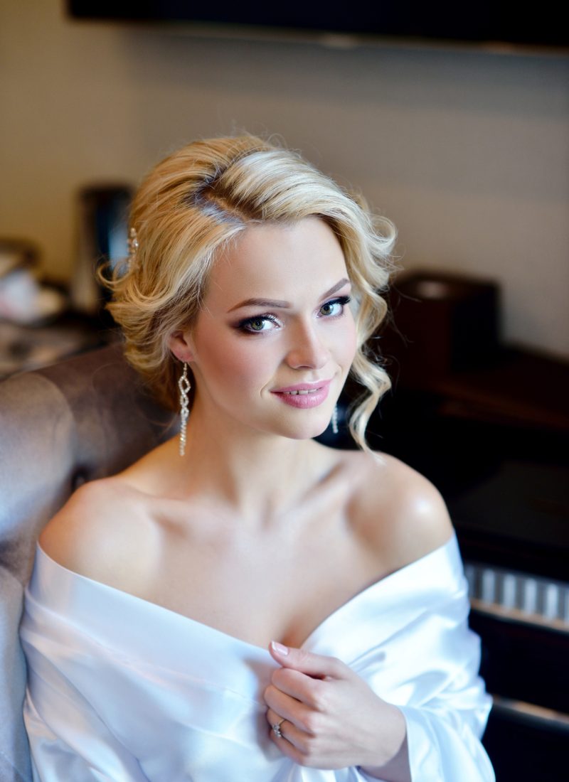 Beauty bride in dressing gown with bridal makeup indoors. Beautiful model girl in colorful wedding robe. Female portrait of cute lady. Woman with hairstyle